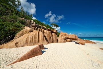 Feiner Sandstrand im Windschatten der Felsen auf La Digue, Seychellen