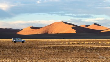 Geländewagen fährt durch die Namib Wüste