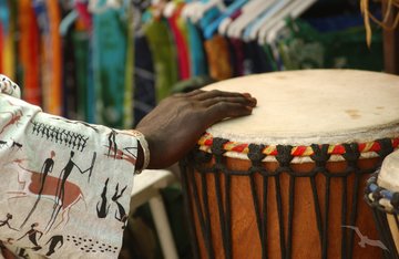 Südafrikaner in traditioneller Tracht macht Musik mit einer Trommel
